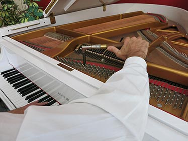 Klavierstimmer Schneider beim Stimmen eines Flügels